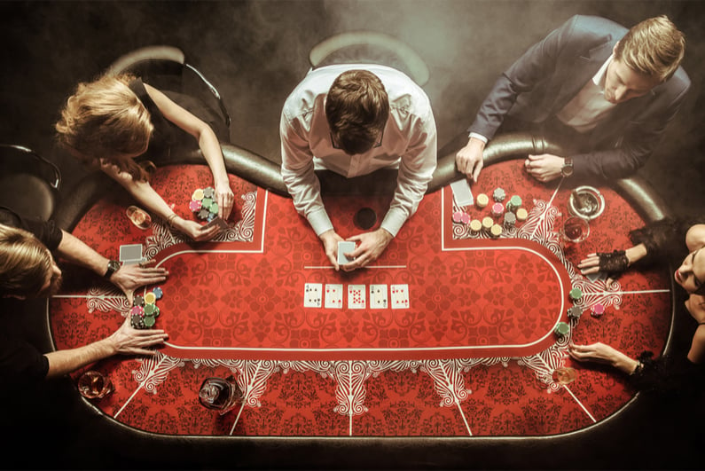 View from above of men and women playing poker in casino