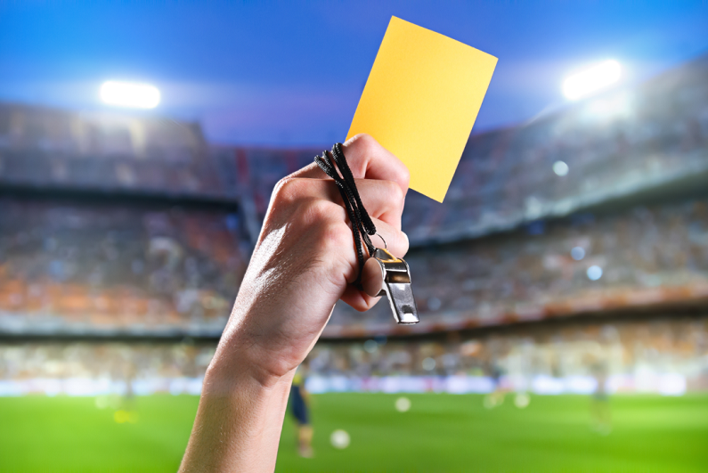 referee with yellow card and whistle