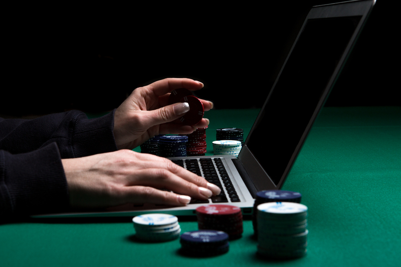 Person with poker chips on laptop